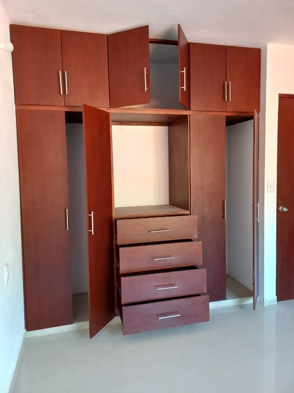 Clóset de madera con cajonera, entrepaños y maletero, terminado e instalado
