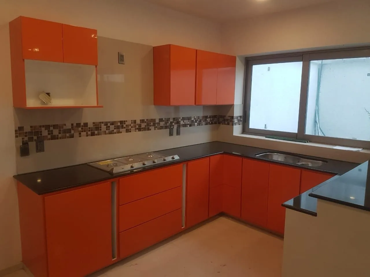 Cocina en U naranja con granito negro